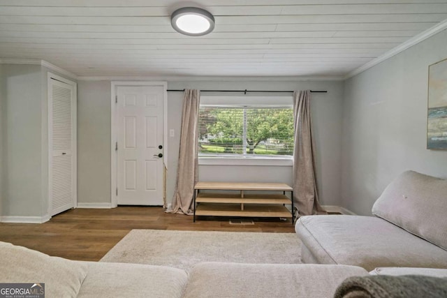 living area with wood finished floors, baseboards, crown molding, and wood ceiling