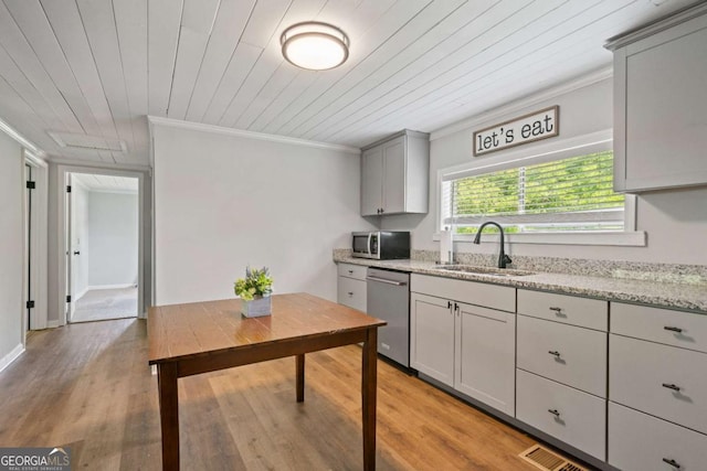 kitchen featuring appliances with stainless steel finishes, a sink, ornamental molding, light wood-style floors, and wooden ceiling