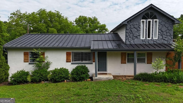 view of front facade featuring a standing seam roof, a front yard, metal roof, and a porch