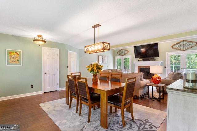 836 Palmetto Tyrone Rd, Sharpsburg, GA 30277 - dining space featuring a fireplace, baseboards, and wood finished floors