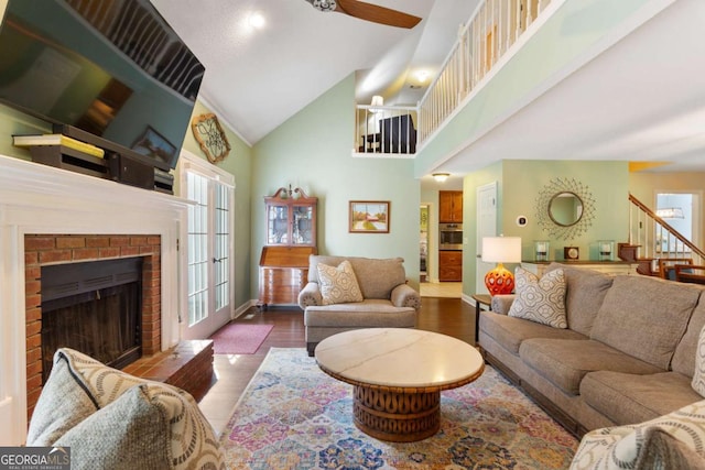 836 Palmetto Tyrone Rd, Sharpsburg, GA 30277 - living area with high vaulted ceiling, wood finished floors, ceiling fan, stairway, and a brick fireplace