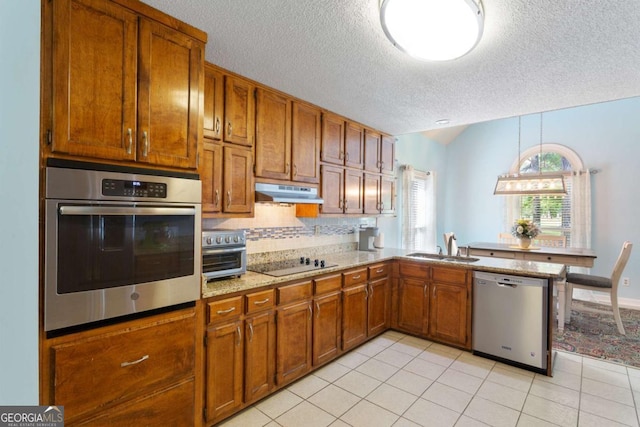 836 Palmetto Tyrone Rd, Sharpsburg, GA 30277 - kitchen featuring stainless steel appliances, a textured ceiling, brown cabinets, backsplash, and under cabinet range hood