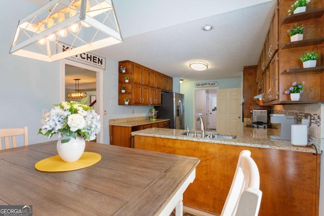 836 Palmetto Tyrone Rd, Sharpsburg, GA 30277 - kitchen with open shelves, stainless steel refrigerator with ice dispenser, brown cabinetry, a sink, and a peninsula