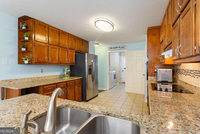 836 Palmetto Tyrone Rd, Sharpsburg, GA 30277 - kitchen with black electric cooktop, a sink, washer / dryer, stainless steel fridge, and open shelves