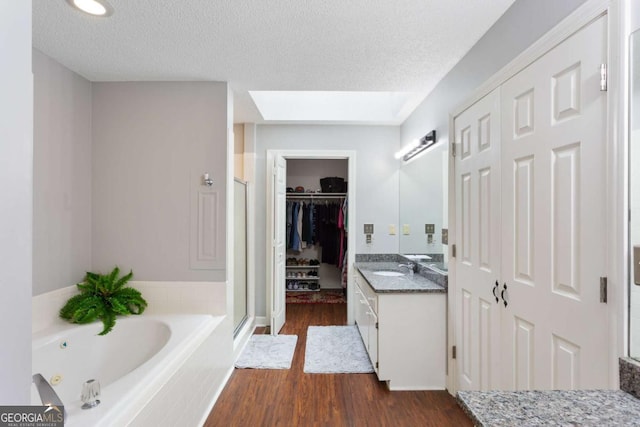 836 Palmetto Tyrone Rd, Sharpsburg, GA 30277 - full bath with vanity, wood finished floors, a shower stall, a whirlpool tub, and a textured ceiling