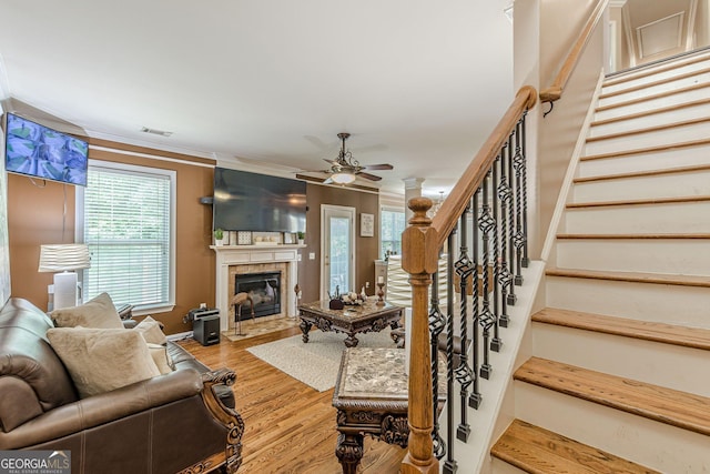 5342 Lakerock Dr SW, South Fulton, GA 30331 - living area featuring stairs, a glass covered fireplace, a ceiling fan, wood finished floors, and crown molding