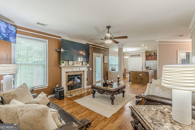 5342 Lakerock Dr SW, South Fulton, GA 30331 - living room with ornamental molding, a ceiling fan, plenty of natural light, light wood-style floors, and a tile fireplace