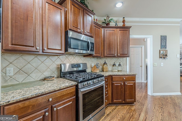 5342 Lakerock Dr SW, South Fulton, GA 30331 - kitchen with stainless steel appliances, ornamental molding, light wood-style floors, light stone countertops, and tasteful backsplash