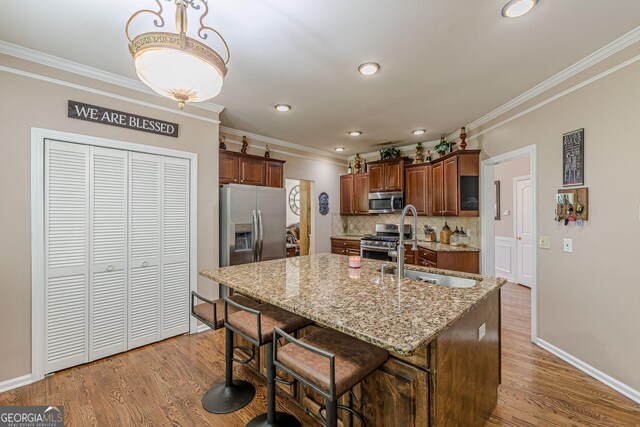 5342 Lakerock Dr SW, South Fulton, GA 30331 - kitchen featuring appliances with stainless steel finishes, a sink, ornamental molding, tasteful backsplash, and light stone counters
