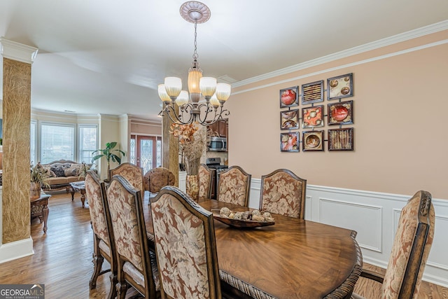 5342 Lakerock Dr SW, South Fulton, GA 30331 - dining room featuring a chandelier, crown molding, wood finished floors, a wainscoted wall, and a decorative wall