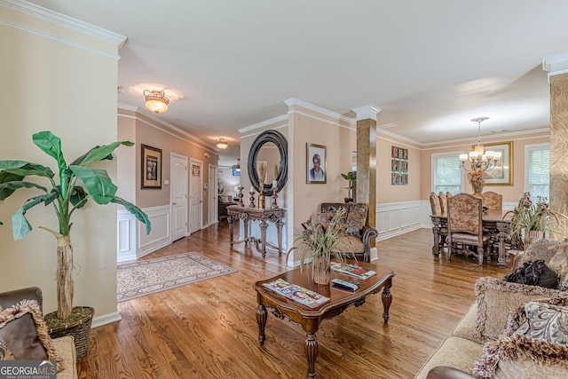 5342 Lakerock Dr SW, South Fulton, GA 30331 - living area with a chandelier, a decorative wall, crown molding, wainscoting, and light wood-style flooring