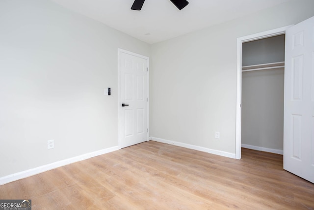 2131 Glendale Dr, Decatur, GA 30032 - unfurnished bedroom featuring baseboards, light wood-type flooring, a closet, ceiling fan, and a walk in closet