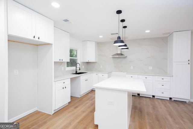 2131 Glendale Dr, Decatur, GA 30032 - kitchen featuring a sink, backsplash, light wood finished floors, recessed lighting, and white cabinetry