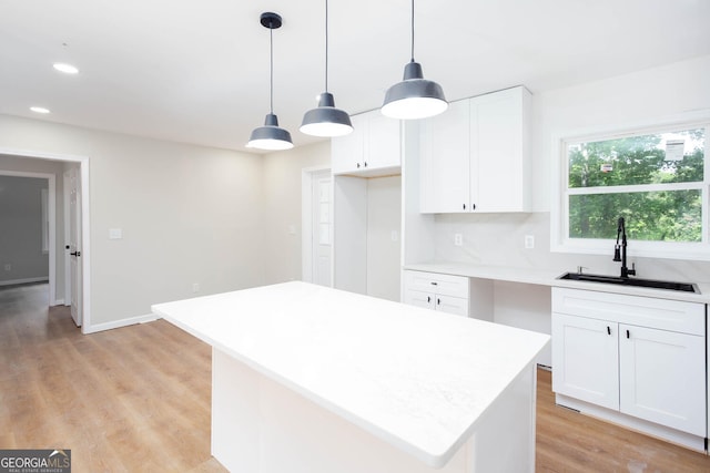 2131 Glendale Dr, Decatur, GA 30032 - kitchen with a sink, light countertops, light wood-style flooring, white cabinets, and recessed lighting