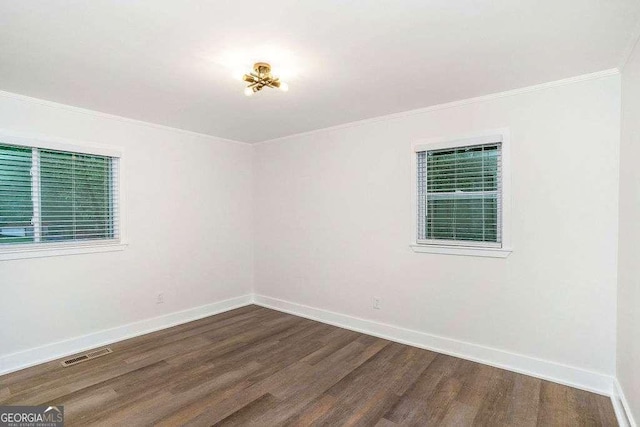 unfurnished room featuring dark wood-style floors, crown molding, and baseboards