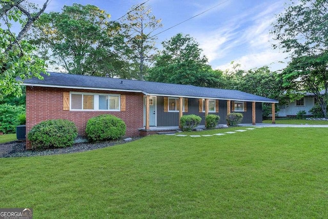 ranch-style home with covered porch, a front yard, central AC, and brick siding