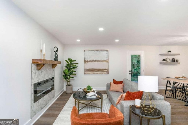 living room featuring wood finished floors, recessed lighting, a glass covered fireplace, and baseboards