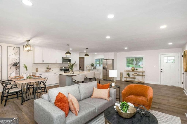 living area with recessed lighting, wood finished floors, and baseboards