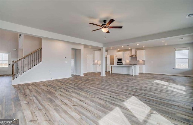 242 Linford Dr, Locust Grove, GA 30248 - unfurnished living room with a ceiling fan, light wood-style floors, plenty of natural light, stairs, and recessed lighting