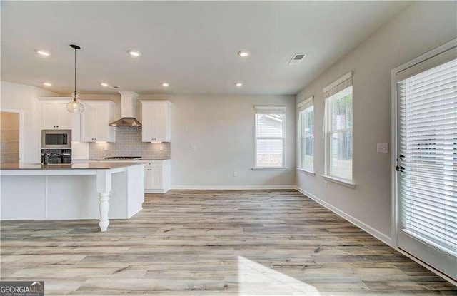 242 Linford Dr, Locust Grove, GA 30248 - kitchen featuring stainless steel appliances, wall chimney range hood, white cabinets, tasteful backsplash, and recessed lighting