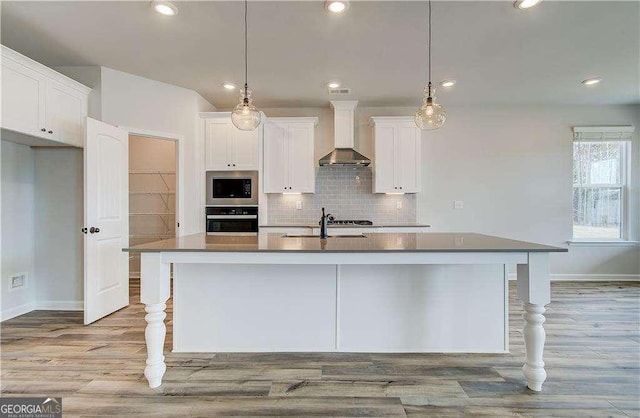 242 Linford Dr, Locust Grove, GA 30248 - kitchen featuring wall chimney range hood, appliances with stainless steel finishes, white cabinets, backsplash, and recessed lighting