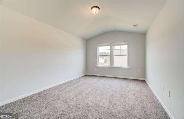 242 Linford Dr, Locust Grove, GA 30248 - carpeted empty room with vaulted ceiling and baseboards