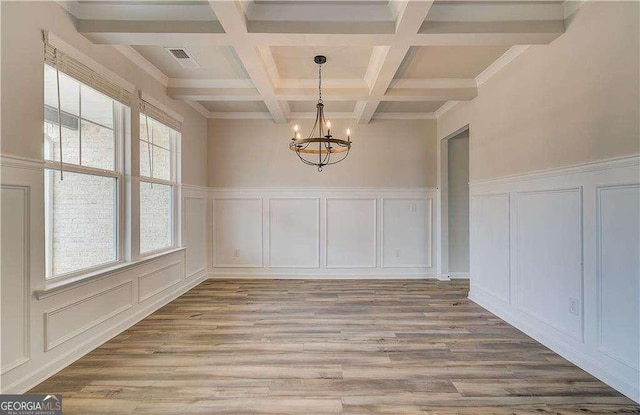 242 Linford Dr, Locust Grove, GA 30248 - unfurnished dining area featuring a decorative wall, a chandelier, beam ceiling, light wood-style floors, and coffered ceiling