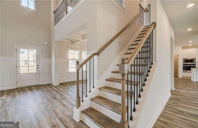 242 Linford Dr, Locust Grove, GA 30248 - foyer entrance with light wood-style flooring, stairway, healthy amount of natural light, a decorative wall, and a wainscoted wall