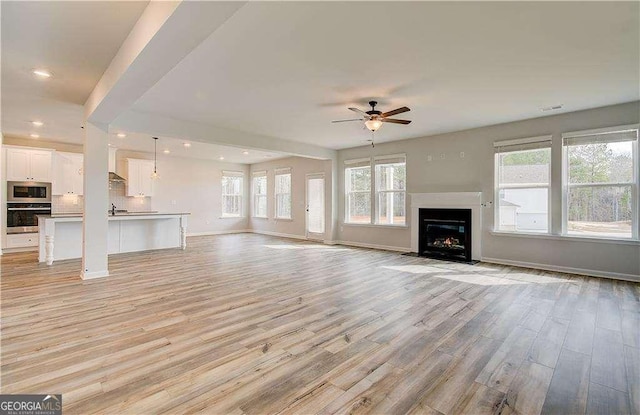 242 Linford Dr, Locust Grove, GA 30248 - unfurnished living room featuring ceiling fan, light wood-style floors, a fireplace with flush hearth, and recessed lighting