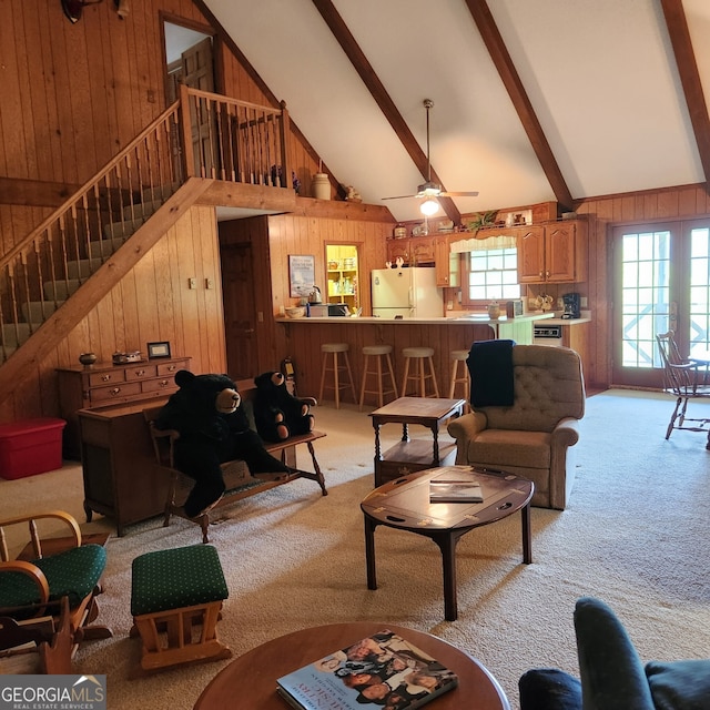 8578 Soapstone Creek Cir, Hiawassee, GA 30546 - living room with wood walls, light colored carpet, high vaulted ceiling, stairway, and beamed ceiling