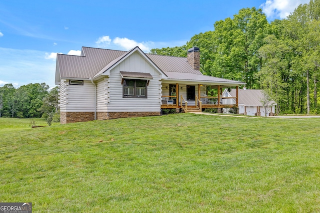 log home featuring covered porch, a chimney, metal roof, and a front lawn