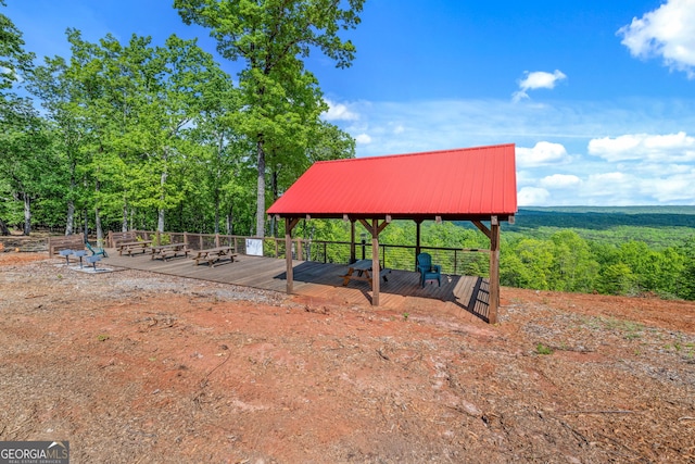 view of jungle gym with a wooden deck and a wooded view