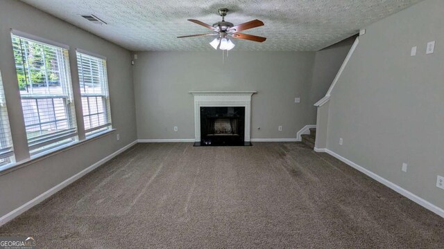 2153 Pine View Trl, Ellenwood, GA 30294 - unfurnished living room featuring ceiling fan, a high end fireplace, a textured ceiling, stairs, and carpet