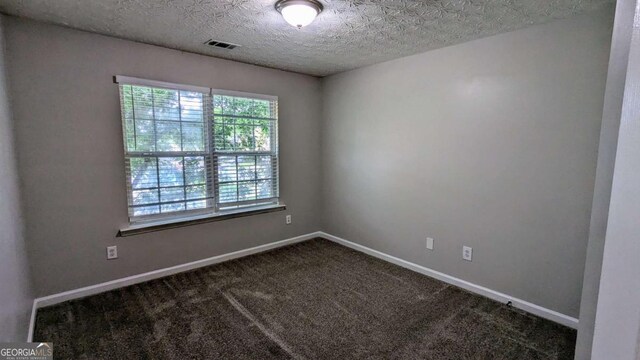 2153 Pine View Trl, Ellenwood, GA 30294 - empty room with dark carpet and a textured ceiling