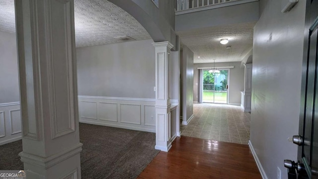 2153 Pine View Trl, Ellenwood, GA 30294 - corridor featuring decorative columns, arched walkways, wood finished floors, a textured ceiling, and a decorative wall