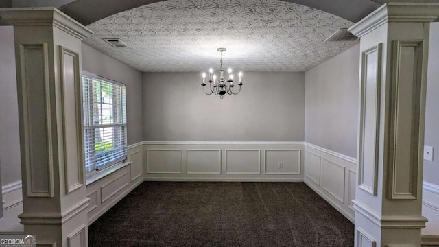 2153 Pine View Trl, Ellenwood, GA 30294 - empty room with a chandelier, ornate columns, wainscoting, dark carpet, and a decorative wall