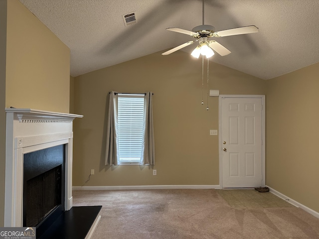 112 Poplar Pointe Ct, Griffin, GA 30224 - unfurnished living room with a fireplace with raised hearth, carpet floors, a ceiling fan, vaulted ceiling, and a textured ceiling