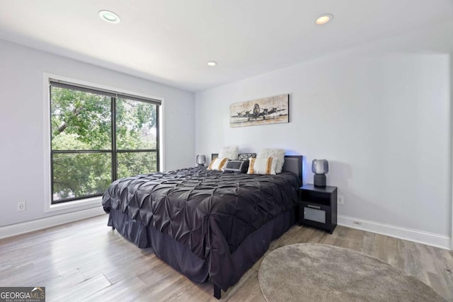 bedroom with wood finished floors, recessed lighting, and baseboards