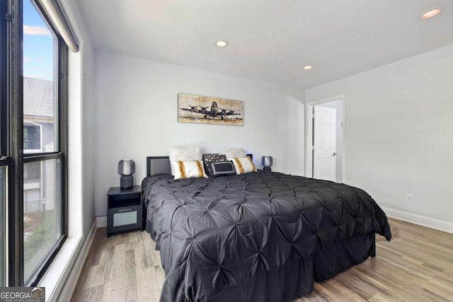 bedroom with multiple windows, light wood-type flooring, baseboards, and recessed lighting