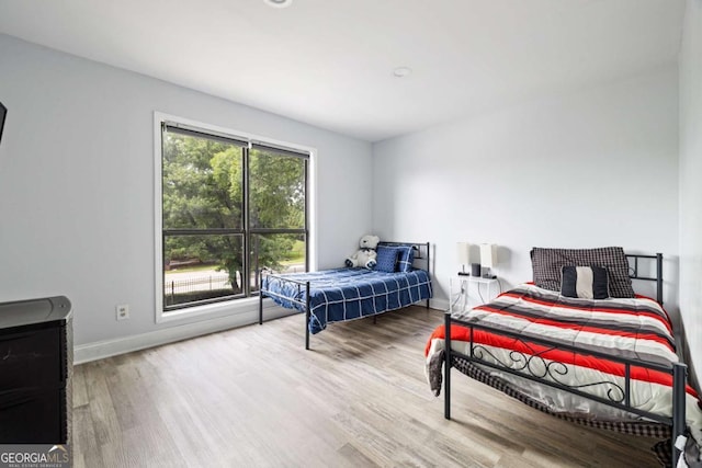 bedroom featuring wood finished floors and baseboards