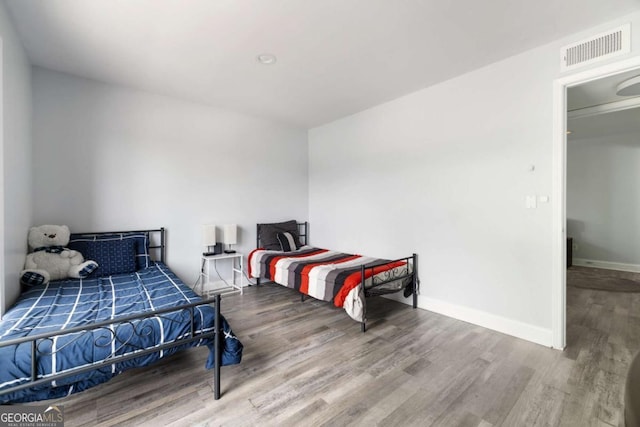 bedroom with wood finished floors and baseboards