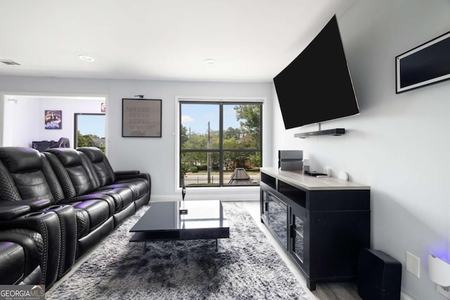 living area with light wood-style flooring, baseboards, and recessed lighting