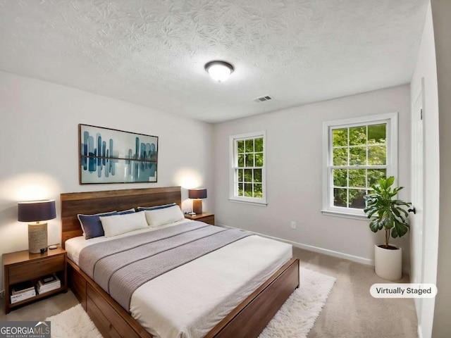 carpeted bedroom with baseboards and a textured ceiling