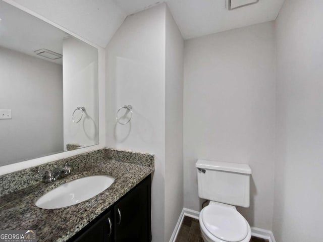 bathroom with baseboards, toilet, and vanity