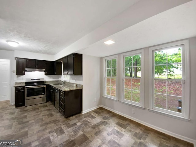 kitchen with electric range, a sink, baseboards, stone finish floors, and under cabinet range hood