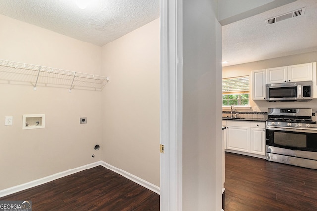 4615 Thermal Ct, Douglasville, GA 30135 - laundry area featuring hookup for an electric dryer, dark wood-style flooring, hookup for a washing machine, a textured ceiling, and baseboards