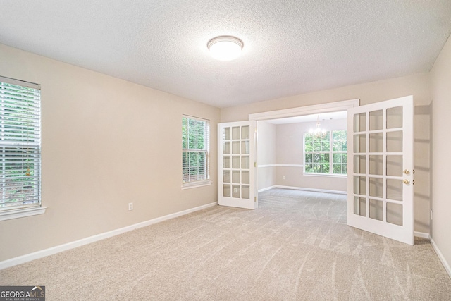 4615 Thermal Ct, Douglasville, GA 30135 - carpeted spare room with french doors, a chandelier, baseboards, and a textured ceiling
