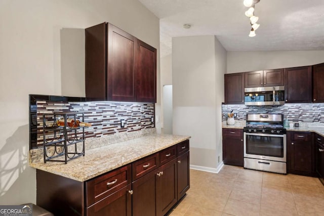 kitchen featuring stainless steel appliances, backsplash, light stone countertops, and lofted ceiling