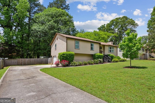 bi-level home with driveway, a garage, and a chimney