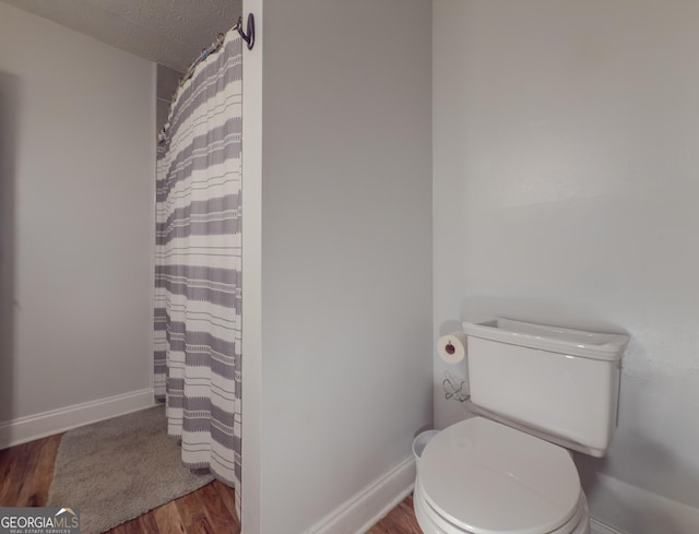 2610 Cumberland Ct, Smyrna, GA 30080 - full bath with wood finished floors, toilet, baseboards, and curtained shower
